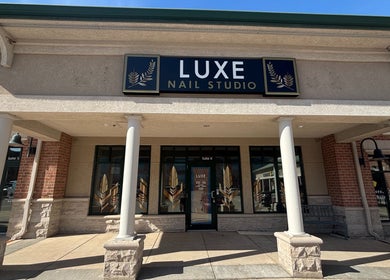 Entrance of Luxe Nail Studio in Madison, Wisconsin, US featuring classic columns and signage.