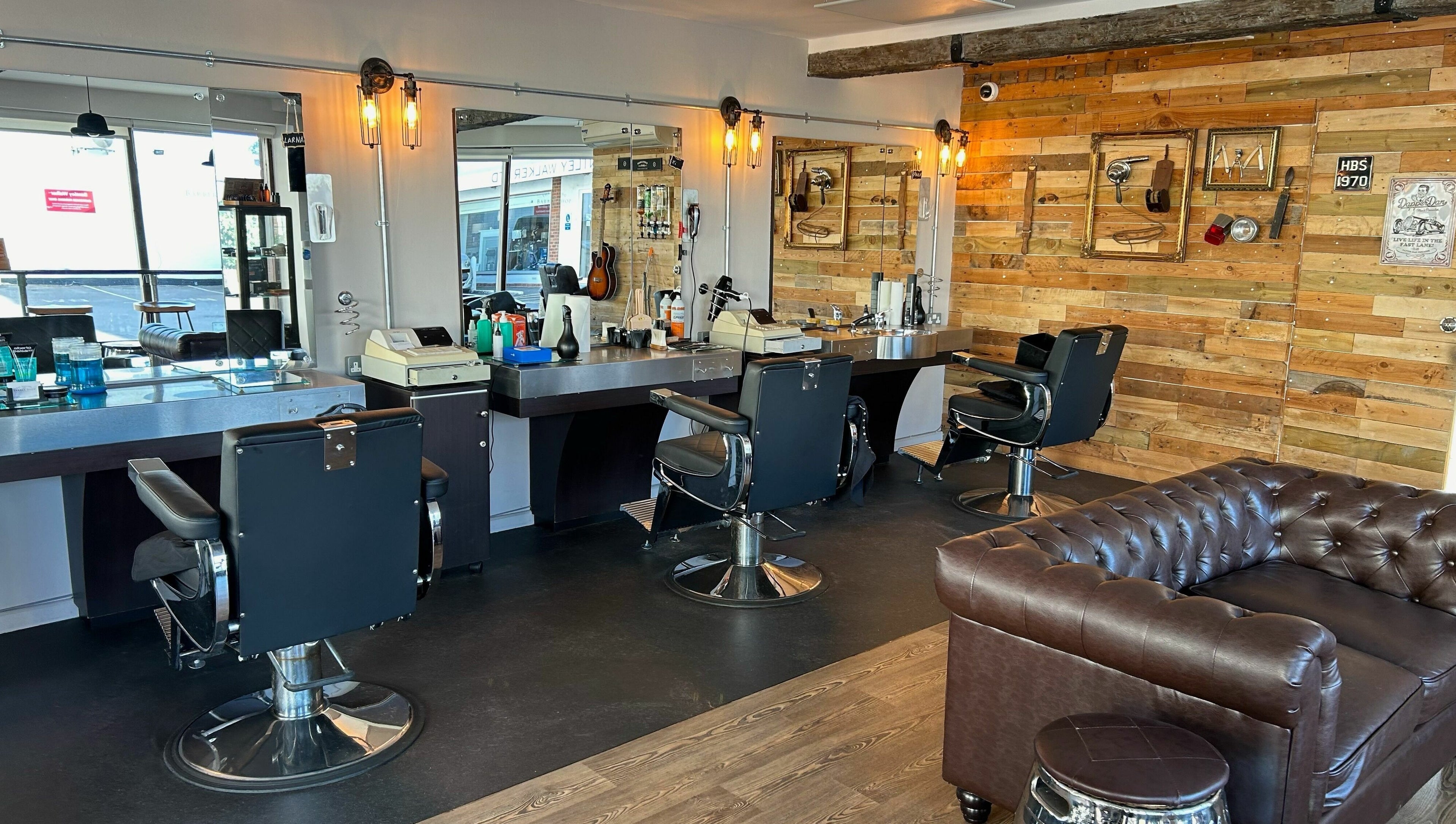 Interior of Hayling Barbershop on Hayling Island, England, showcasing stylish chairs and rustic decor.