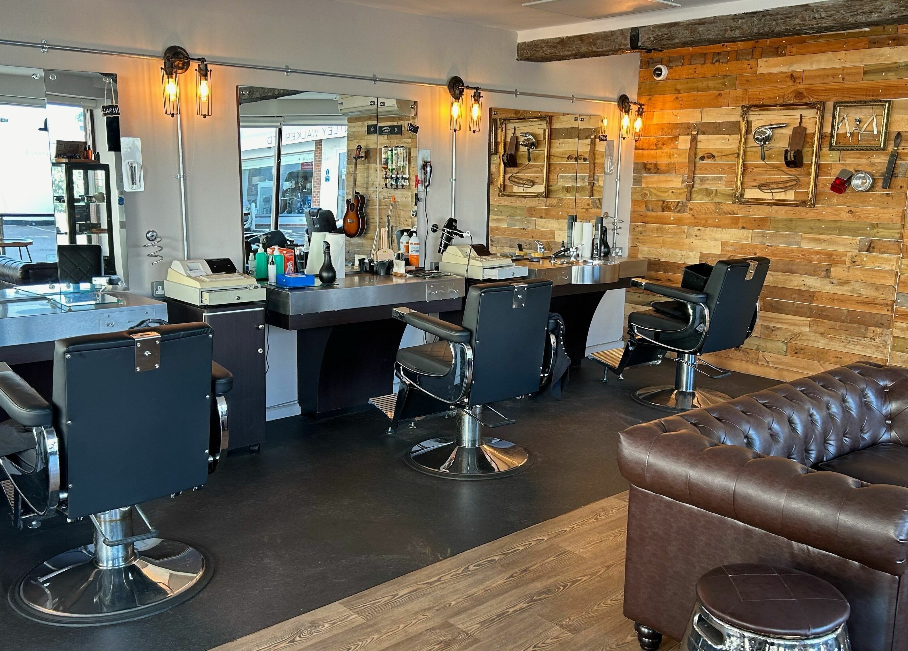 Interior of Hayling Barbershop on Hayling Island, England, showcasing stylish chairs and rustic decor.