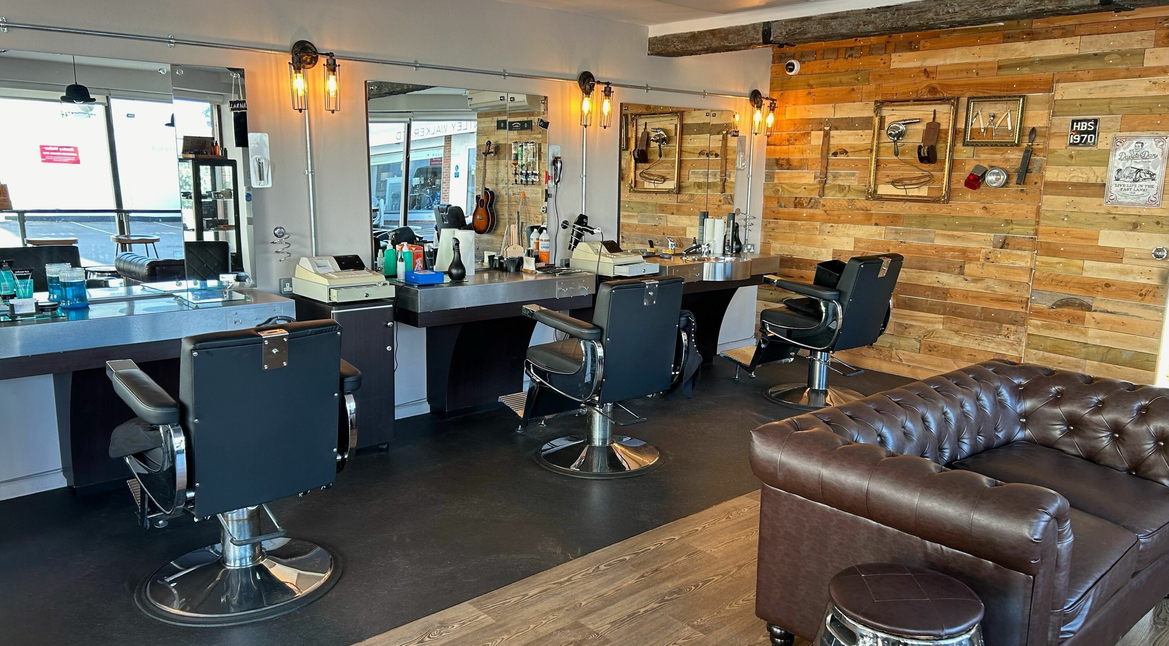 Interior of Hayling Barbershop on Hayling Island, England, showcasing stylish chairs and rustic decor.