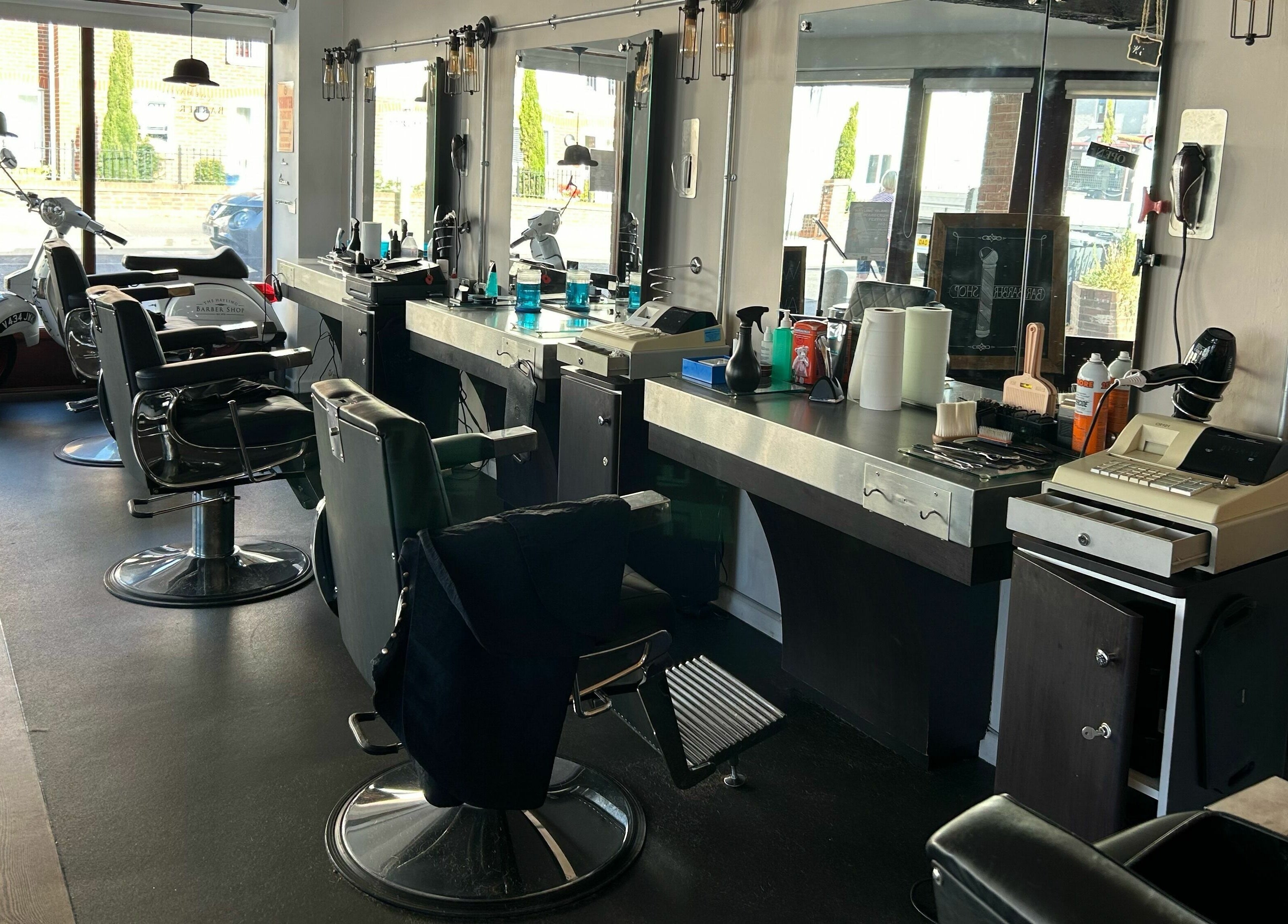 Stylish interior of Hayling Barbershop on Hayling Island, England, GB featuring barber chairs and mirrors.