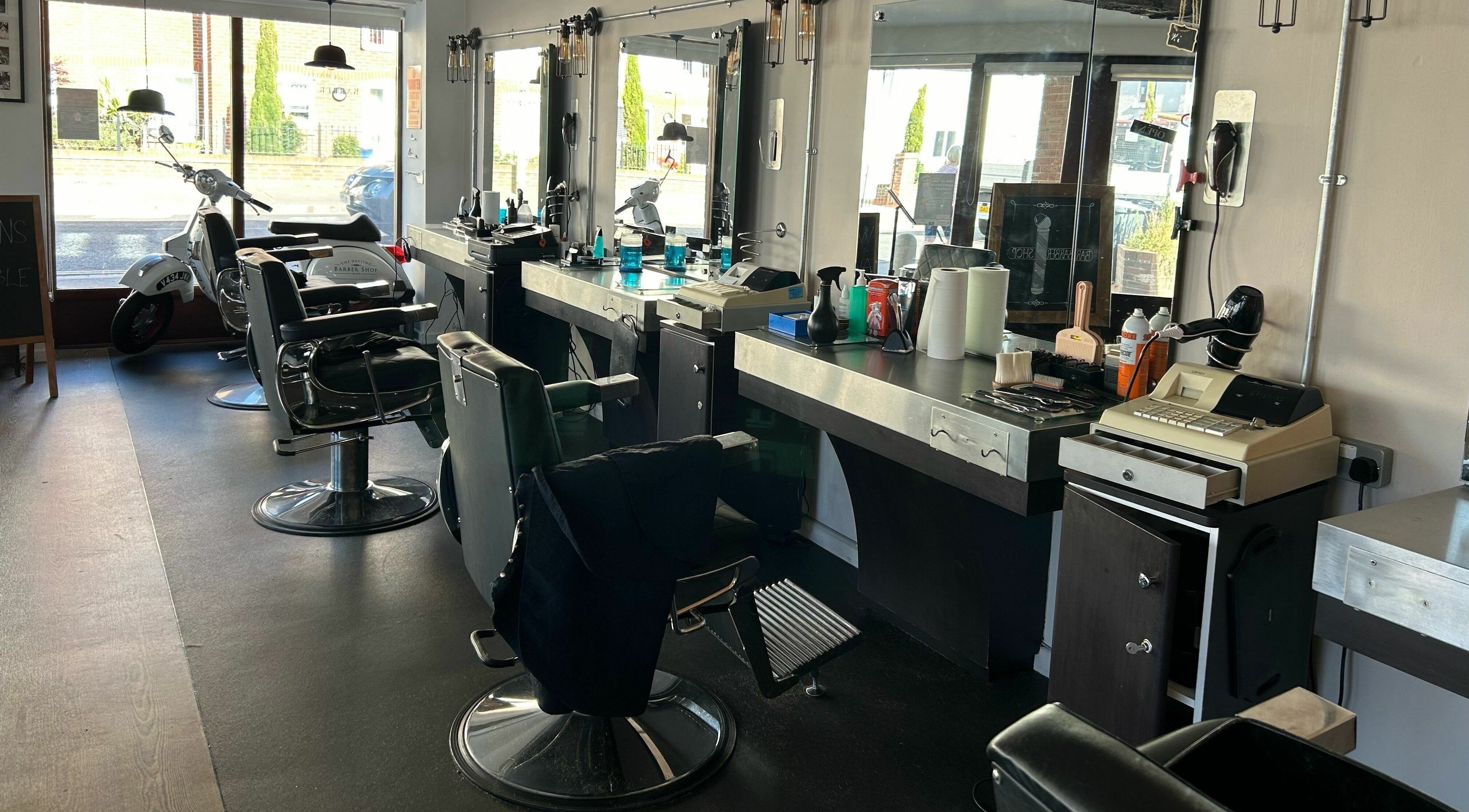 Stylish interior of Hayling Barbershop on Hayling Island, England, GB featuring barber chairs and mirrors.