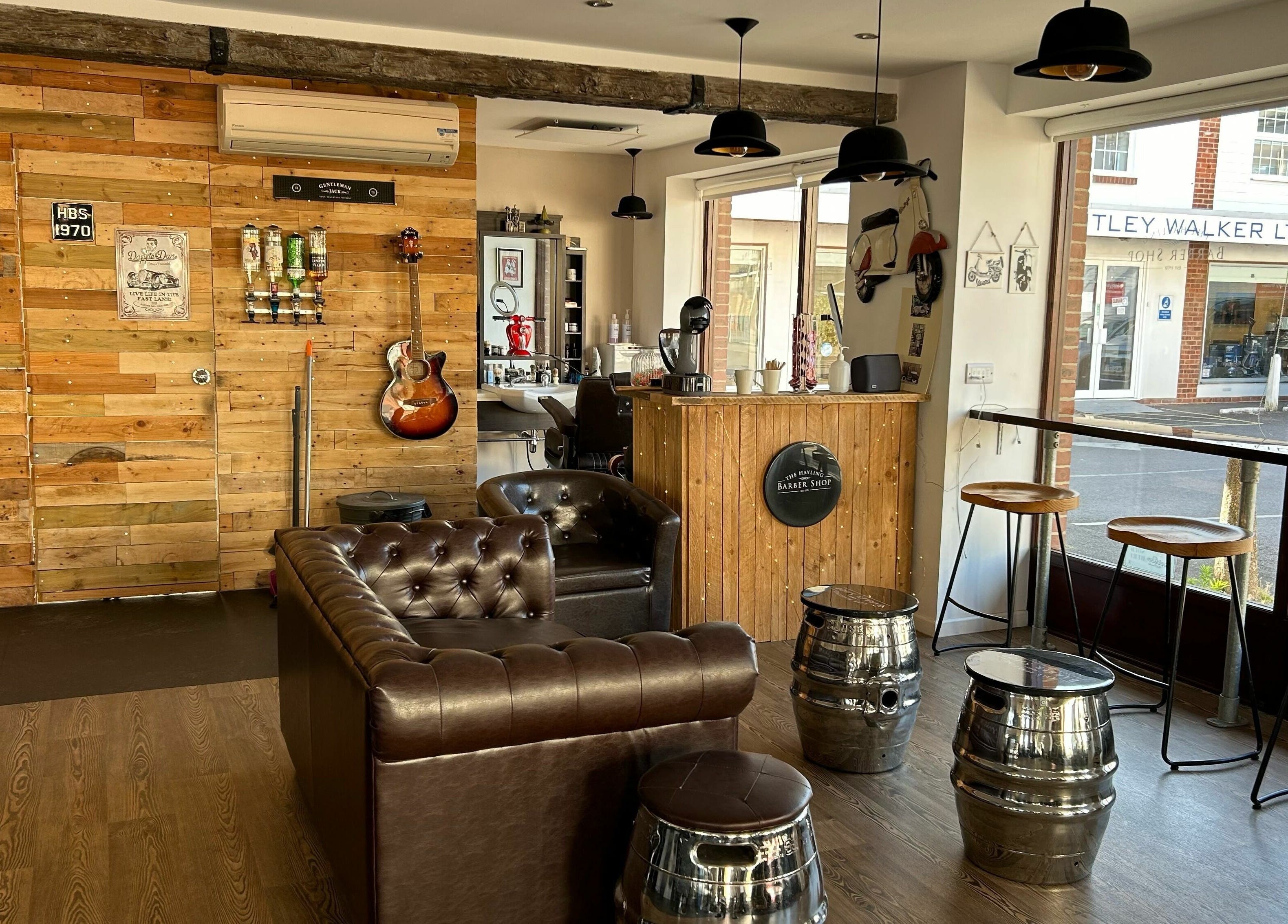 Cozy interior of Hayling Barbershop on Hayling Island, England, GB with leather seating and wooden decor.