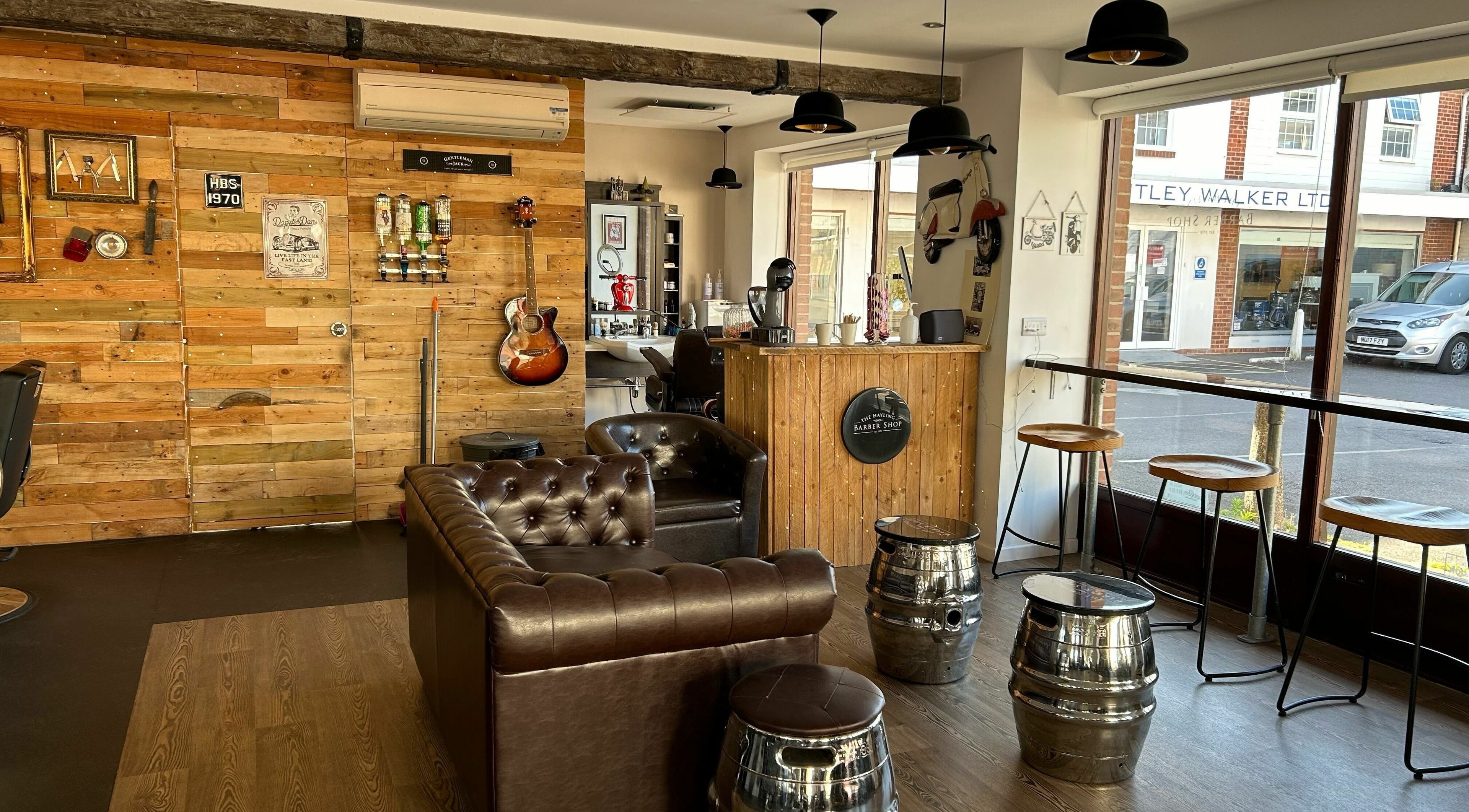 Cozy interior of Hayling Barbershop on Hayling Island, England, GB with leather seating and wooden decor.