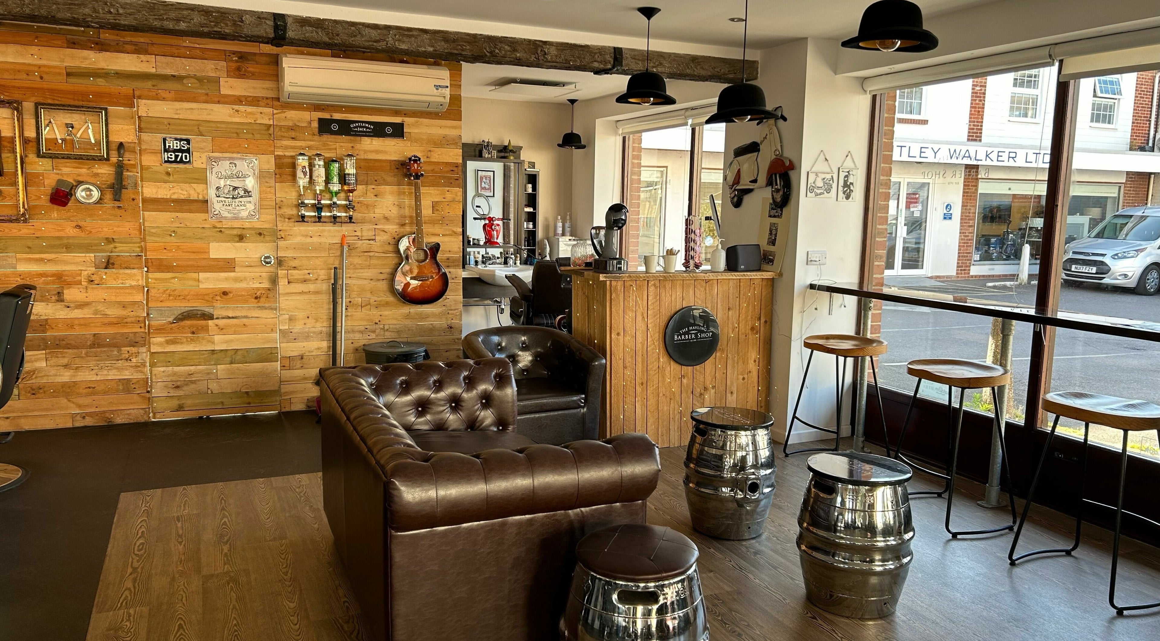 Cozy interior of Hayling Barbershop on Hayling Island, England, GB with leather seating and wooden decor.