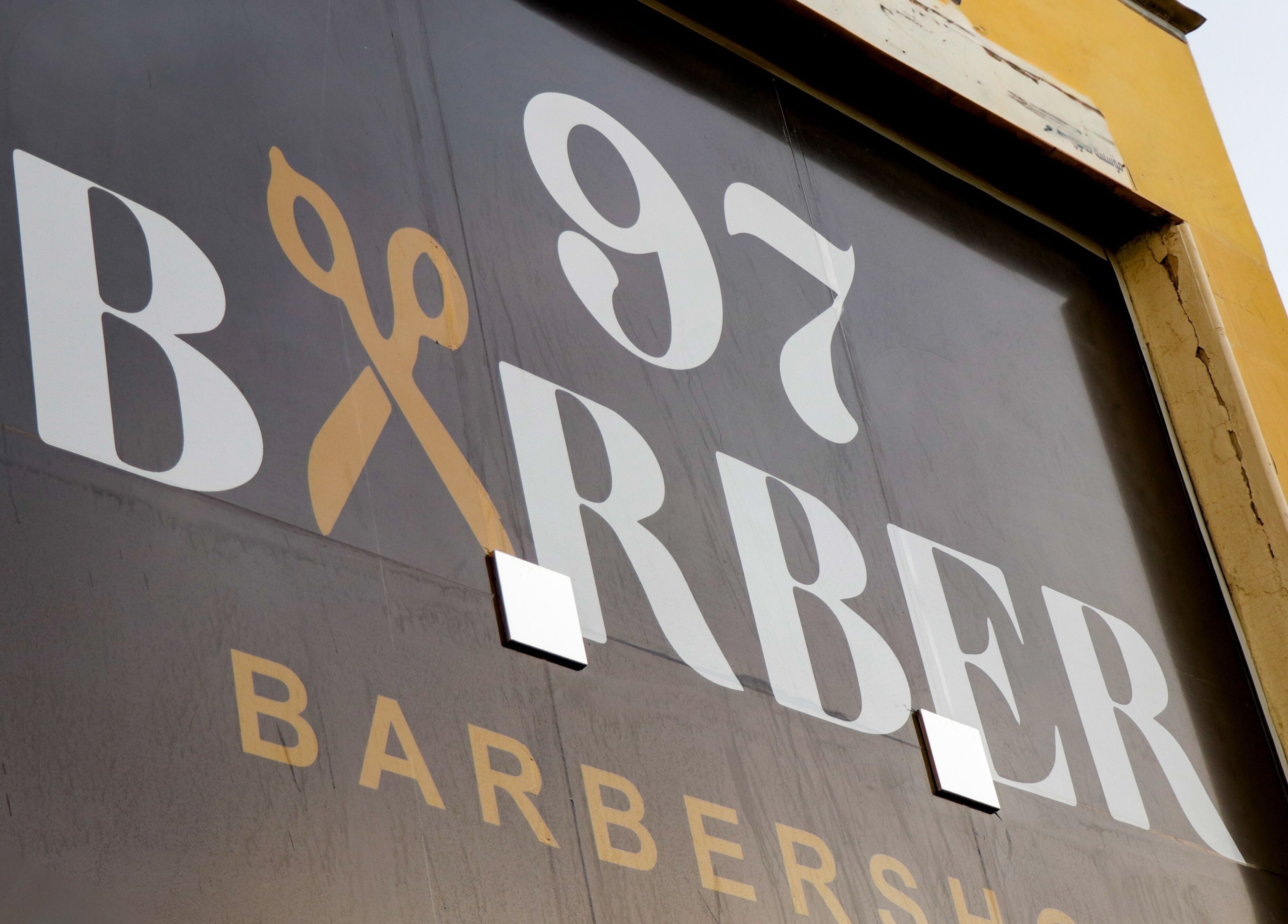 Barbershop 97 صالون exterior sign at الخبر, المنطقة الشرقية, SA, featuring bold lettering and scissors graphic.