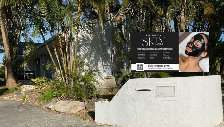 Entrance to The Pretty Skin Society in Warana, Queensland, AU, with lush greenery and modern signage.