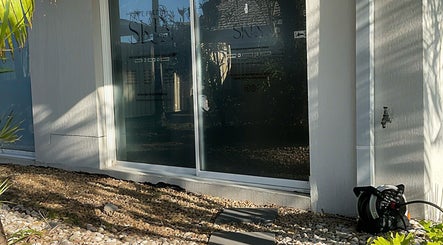 Exterior view of The Pretty Skin Society in Warana, Queensland, showing reflective glass windows and modern design.