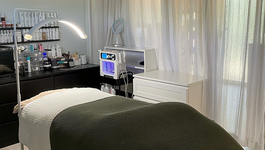 Relaxing spa room at The Pretty Skin Society in Warana, Queensland, AU with treatment bed and skincare products.