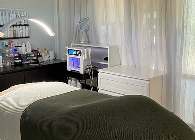 Relaxing spa room at The Pretty Skin Society in Warana, Queensland, AU with treatment bed and skincare products.