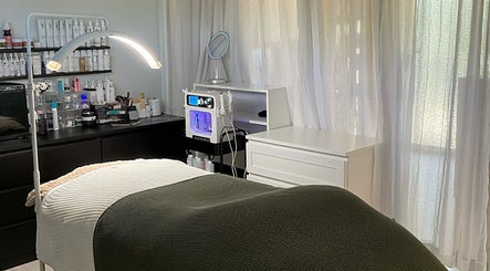 Relaxing spa room at The Pretty Skin Society in Warana, Queensland, AU with treatment bed and skincare products.