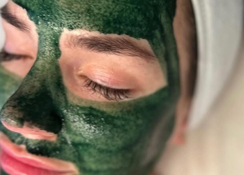 Close-up of a person with a green face mask at The Pretty Skin Society, Warana, Queensland, AU.
