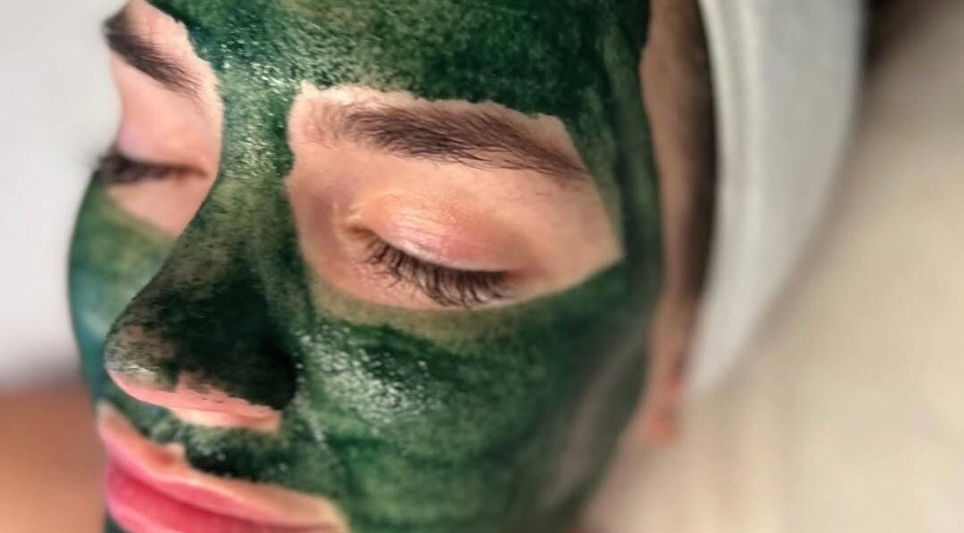 Close-up of a person with a green face mask at The Pretty Skin Society, Warana, Queensland, AU.