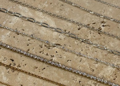 Elegant chain designs showcased at Solderella Studio, Melbourne, Victoria, AU on textured surface.