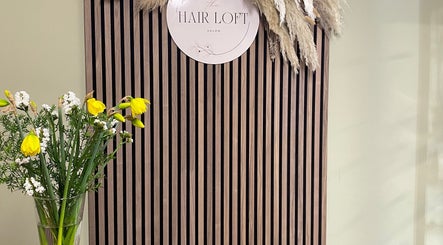 Elegant SC Hair Design entrance in Thirsk, England, GB with stylish paneling and vibrant flower arrangement.