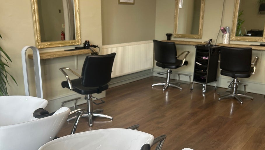 Modern styling area at SC Hair Design, Thirsk, England with sleek black chairs and mirrors