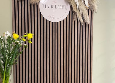 Stylish decor at SC Hair Design in Thirsk, England, featuring flowers on a striped wooden panel.