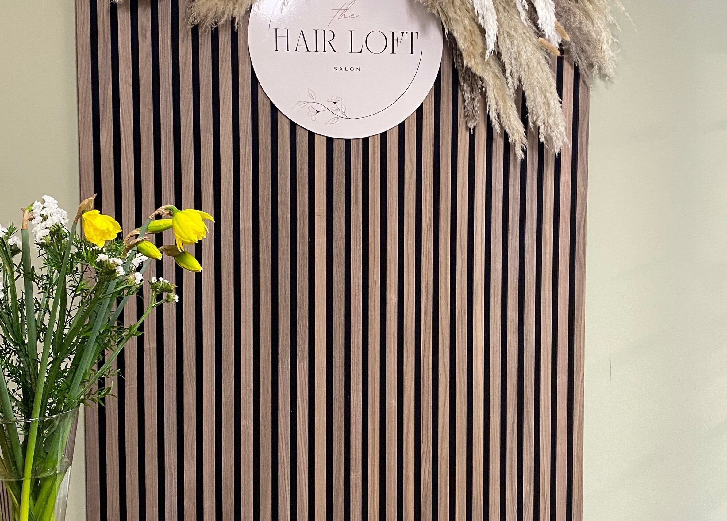 Stylish decor at SC Hair Design in Thirsk, England, featuring flowers on a striped wooden panel.