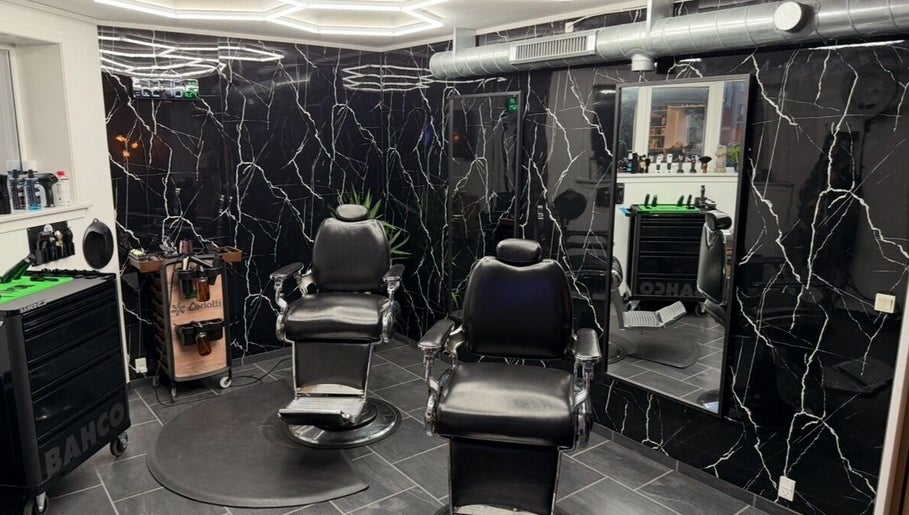 Modern barber chairs in B the barber, Tórshavn, Streymoyar, FO with sleek black marble decor.