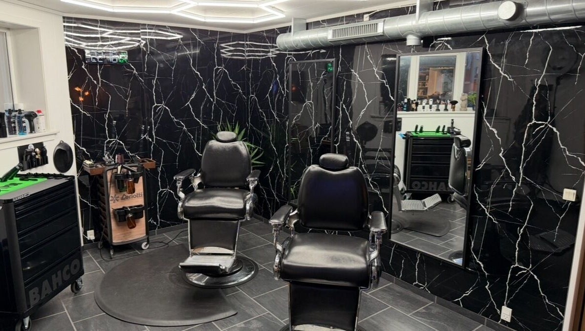 Elegant barber chairs at B the barber, Tórshavn, Streymoyar, FO, with sleek black decor and mirrors.