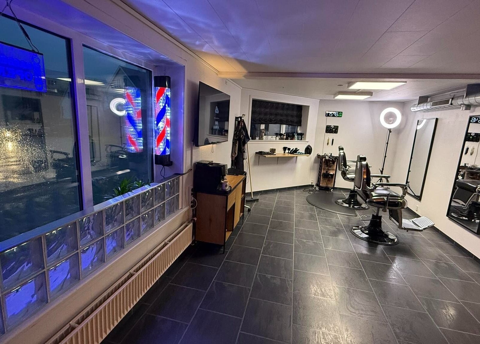 Interior of B the barber in Tórshavn, Streymoyar, FO showcasing sleek chairs and vibrant decor.