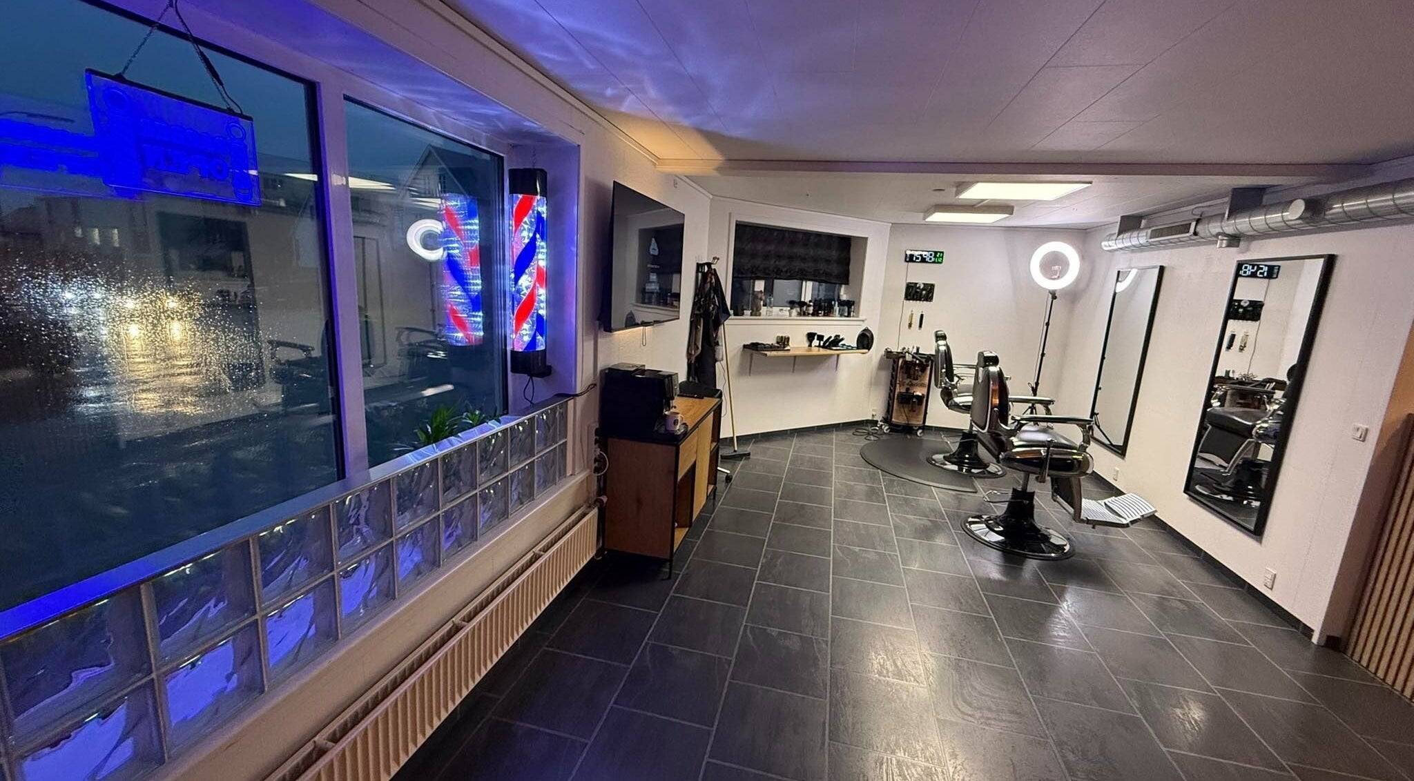 Interior of B the barber in Tórshavn, Streymoyar, FO showcasing sleek chairs and vibrant decor.