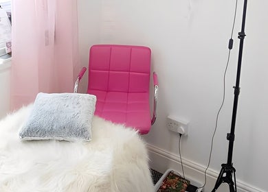 Relaxing treatment area at Lotus Skin, Beauty and Wellness, Mansfield, England, GB with a pink chair and fluffy decor.