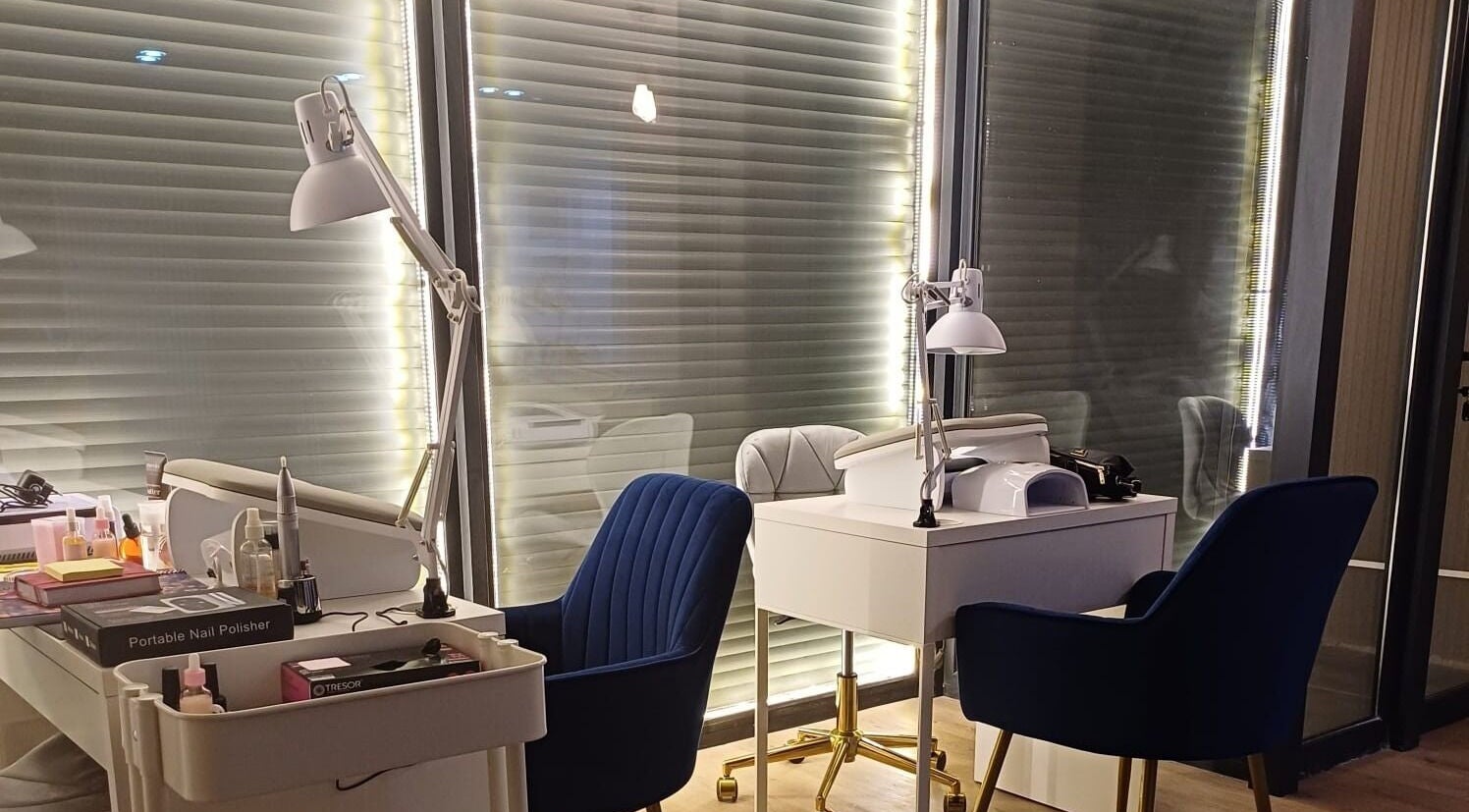 Estación de manicura elegante en Mood Nails, Ñuñoa, Región Metropolitana, CL, con sillas azules y lámparas modernas.