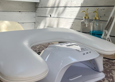 Manicure station at Glow Nails in Bournemouth, England, GB with nail tools and a modern white chair.