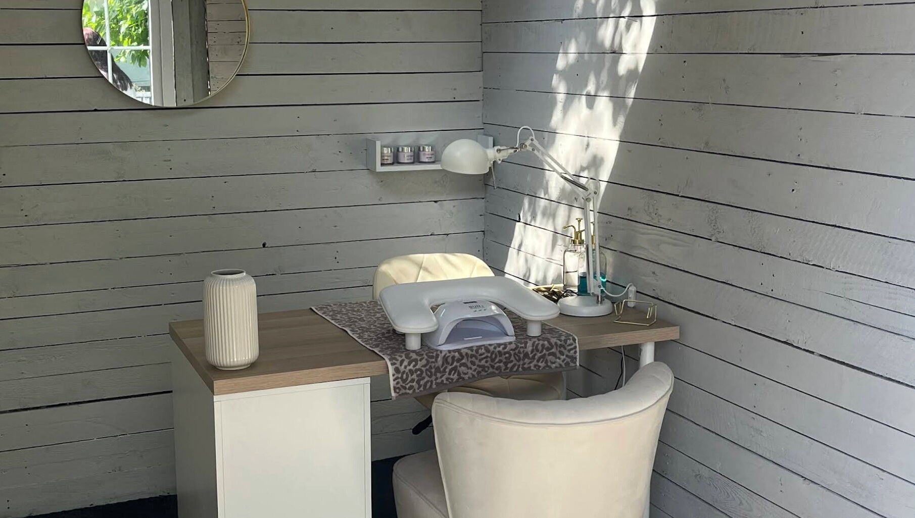 Cozy nail station at Glow Nails, Bournemouth, England, GB with a stylish white chair and wooden desk.