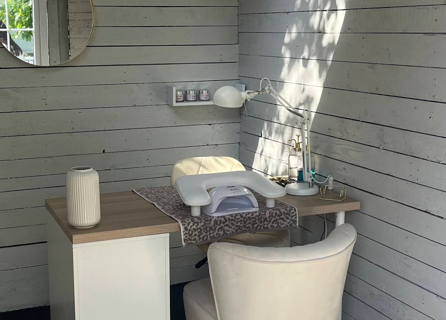 Cozy nail station at Glow Nails, Bournemouth, England, GB with a stylish white chair and wooden desk.