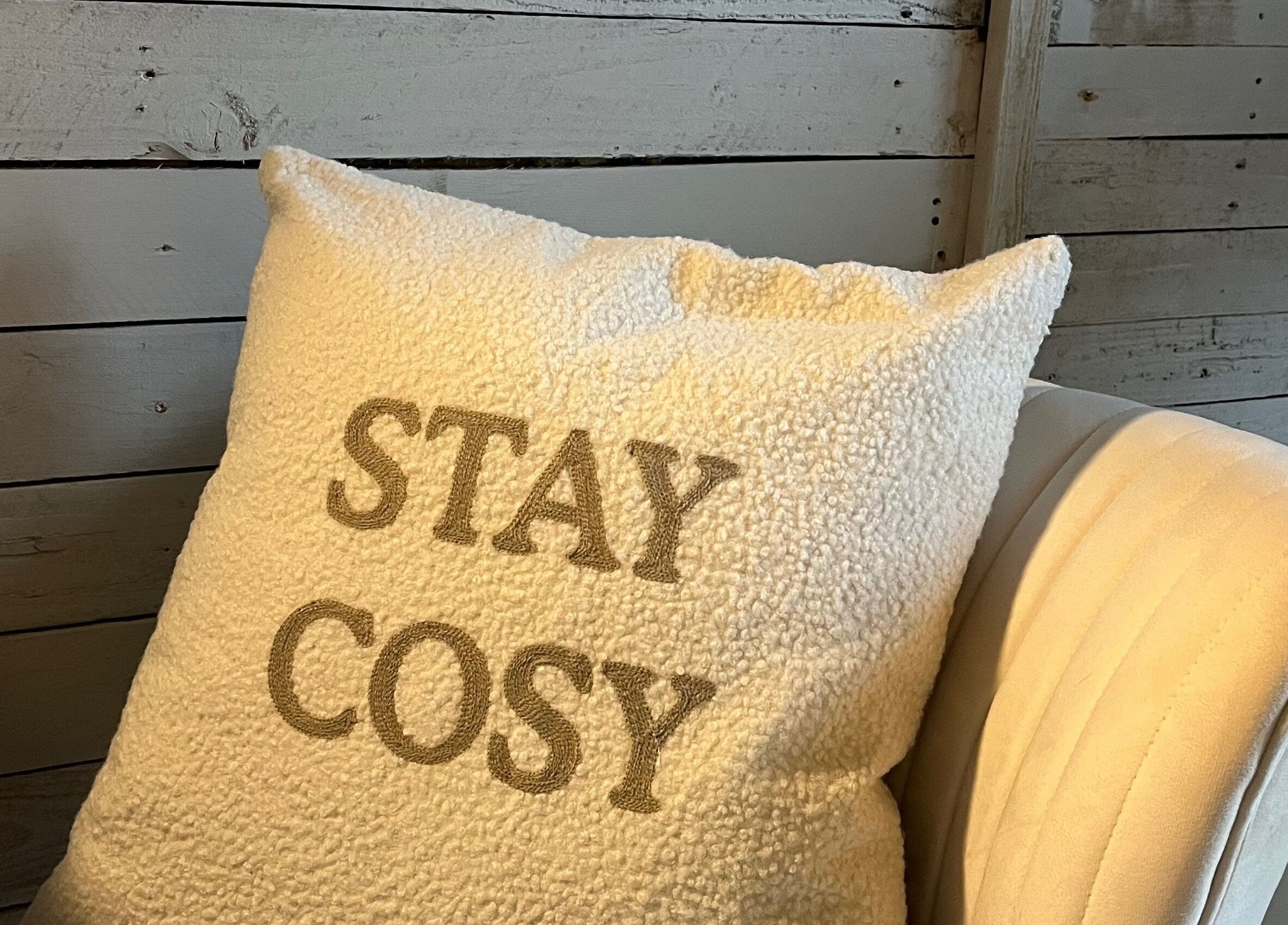 Comfortable white chair with 'Stay Cosy' pillow at Glow Nails, Bournemouth, England, GB.