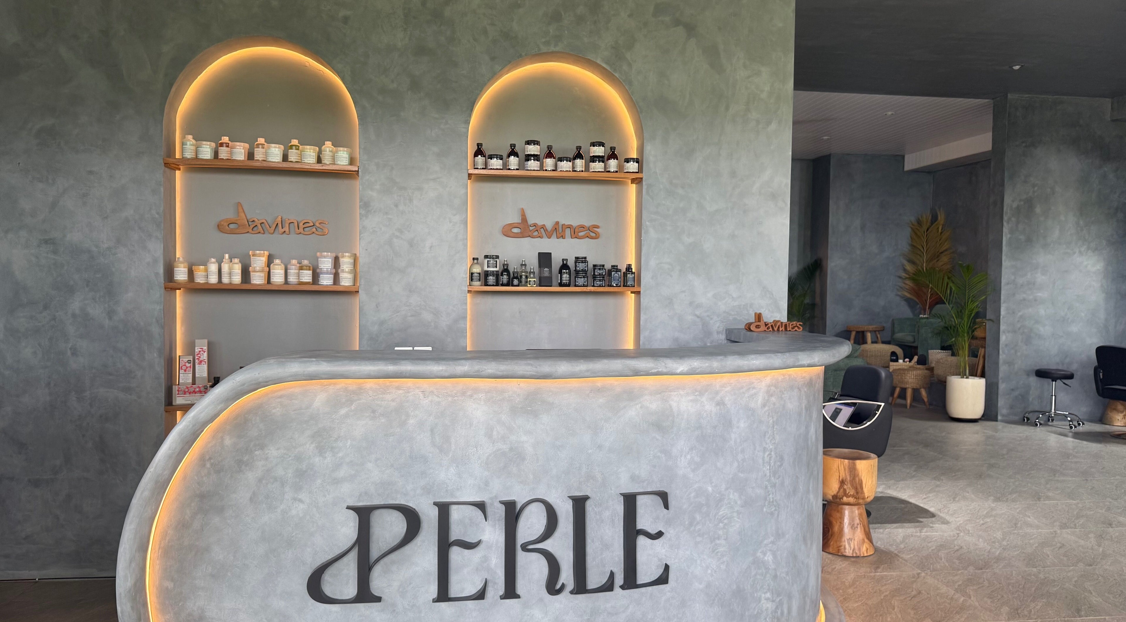 Reception area of Perle Hair & Nail Studio in Bali, Denpasar, ID, featuring stylish decor and product displays.