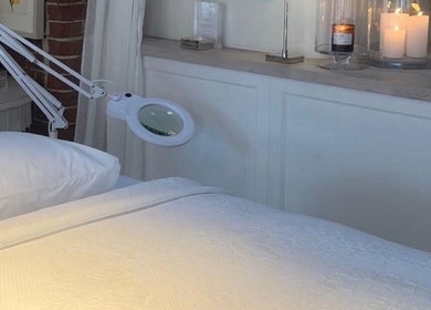 Relaxing treatment room at AURA 37 in Burnham Market, England, GB with a massage table and candles.