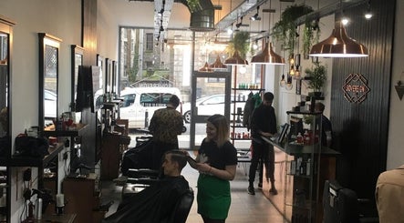 Interior of Sovereign salon in Aberdeen, Scotland, GB with stylists and customers in a modern, vibrant setting.
