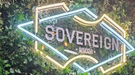 Illuminated Sovereign sign amidst green foliage in Aberdeen, Scotland, GB.