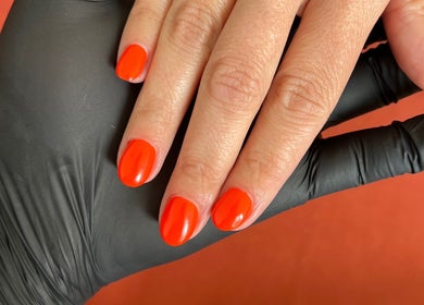 Bright orange manicure by Lumiere Mobile Beauty Services in Cambridge, England, GB.