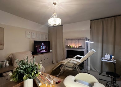 Luxurious treatment room at Lumiere Beauty, Cambridge, England, GB with spa bed, art, and warm lighting.