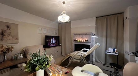 Luxurious treatment room at Lumiere Beauty, Cambridge, England, GB with spa bed, art, and warm lighting.