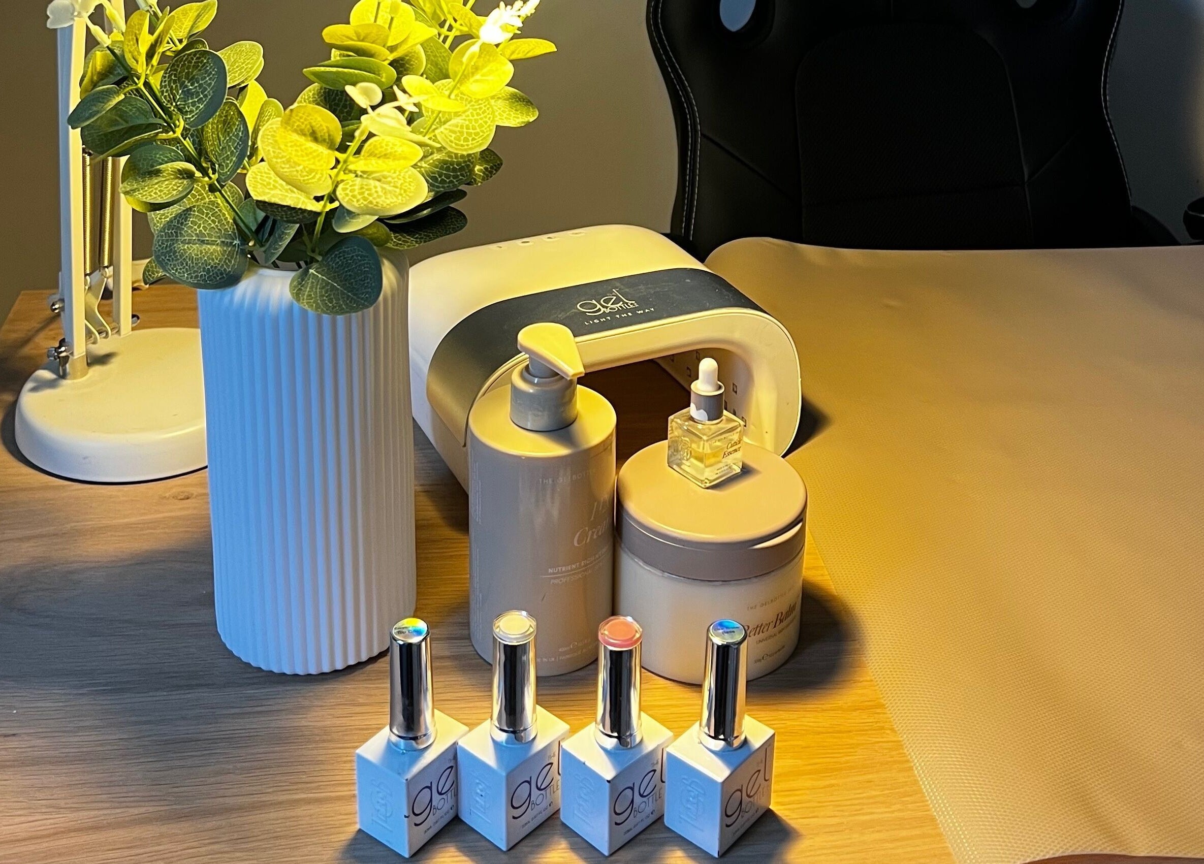 Manicure station at Lumiere Beauty, Cambridge, England, GB with nail polishes and plant decor.