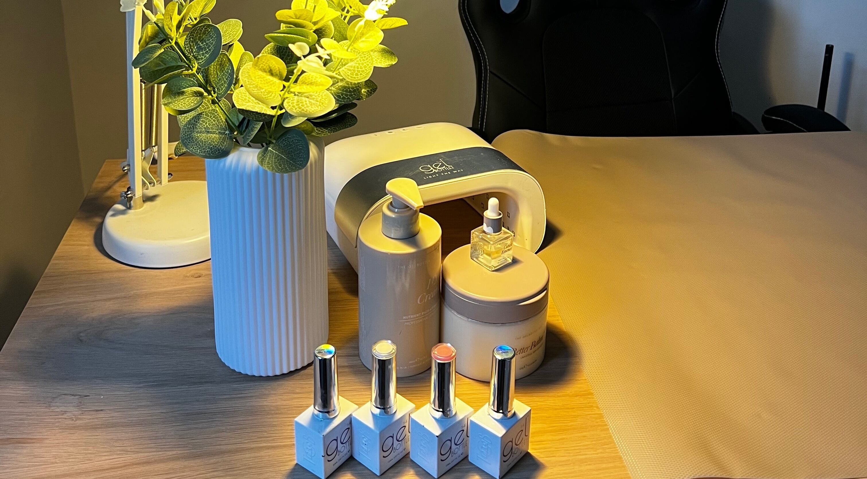 Manicure station at Lumiere Beauty, Cambridge, England, GB with nail polishes and plant decor.