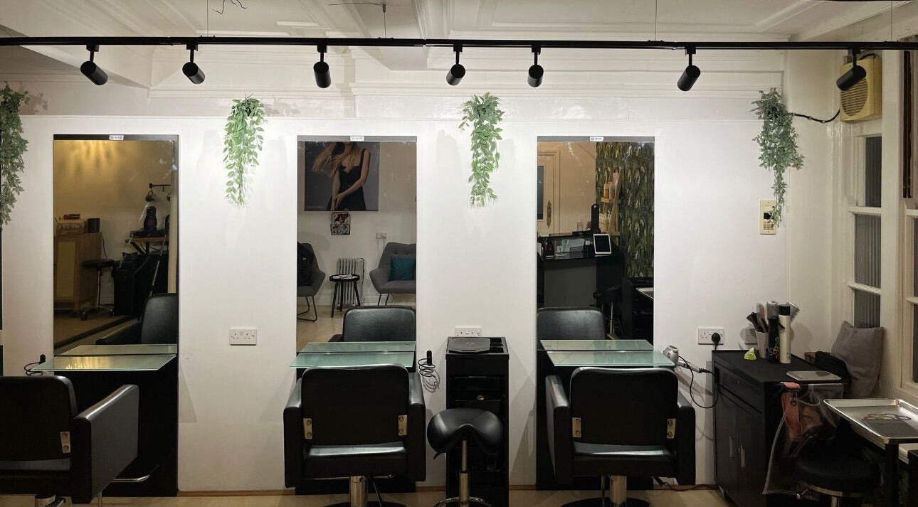 Modern salon interior at Niamh Monaghan Hair, Norwich, England, GB. Sleek styling stations and contemporary decor.