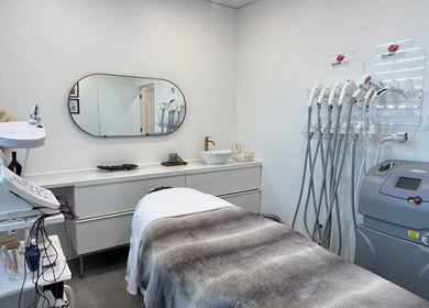 Salle de soin moderne à Clinique Esthélaser, Laval, Québec, CA, avec équipement avancé pour traitements esthétiques.