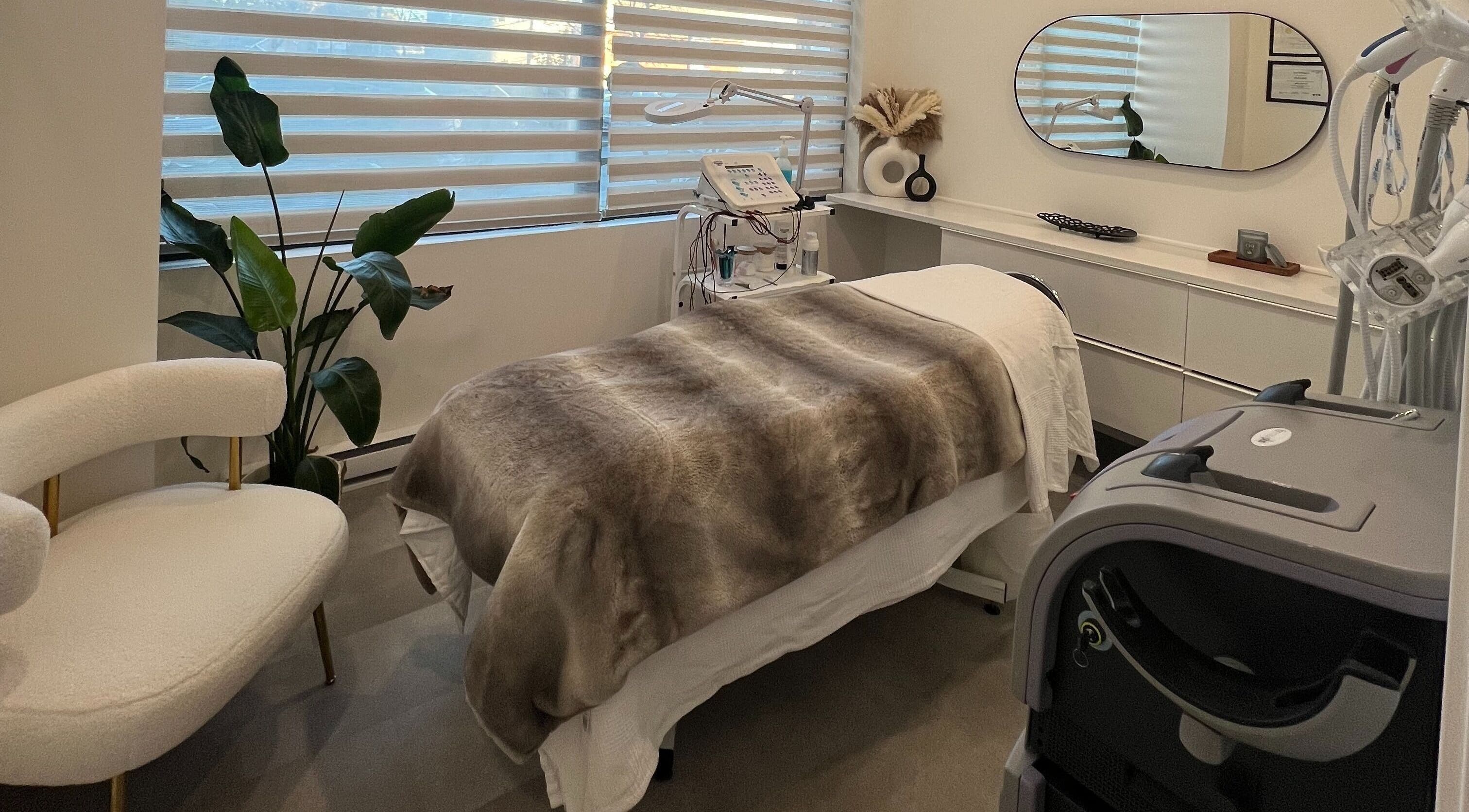 Salle de soin moderne chez Clinique Esthélaser, Laval, Québec, CA, avec table de massage et décoration élégante.