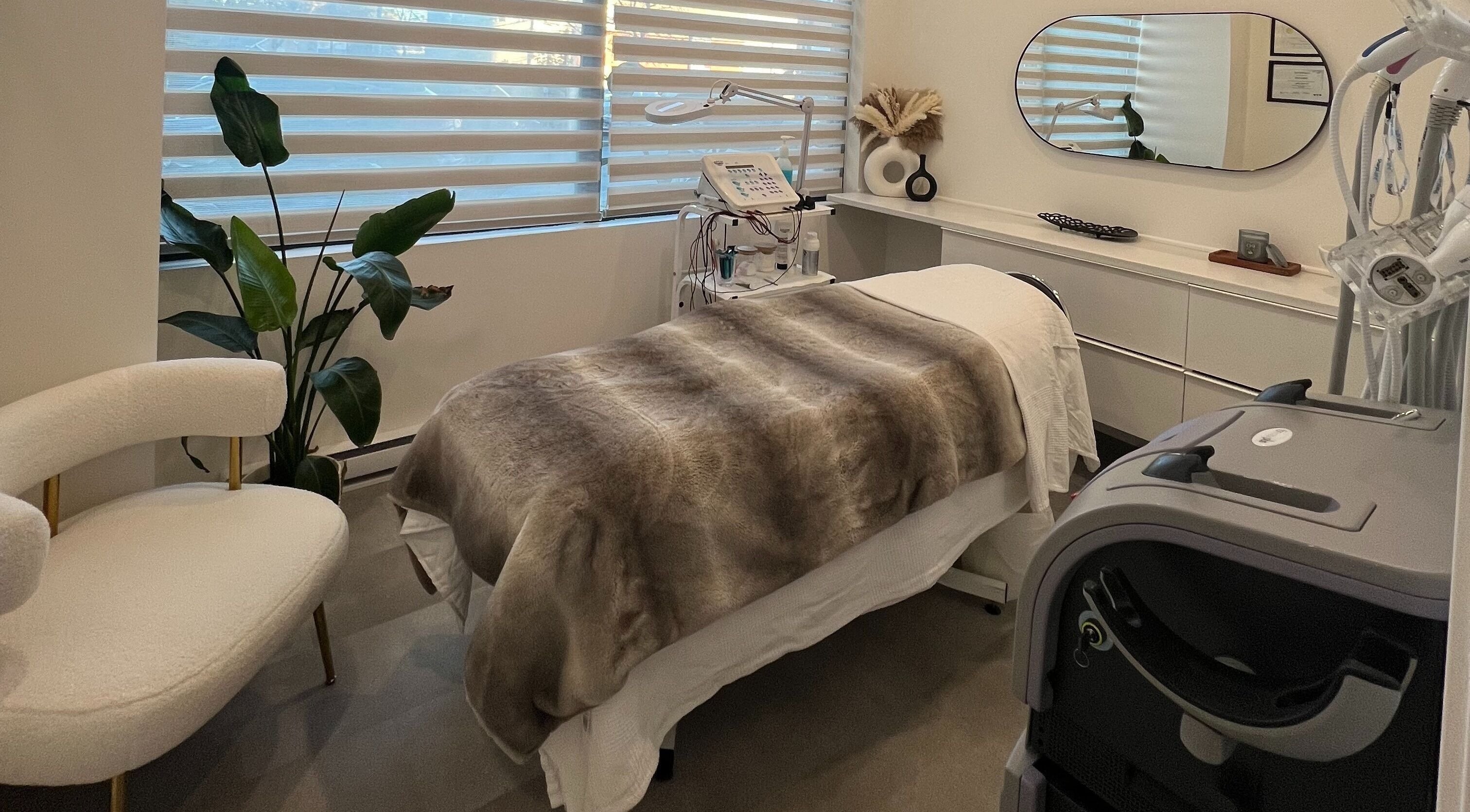 Salle de soins de Clinique Esthélaser à Laval, Québec, CA, avec lit de traitement et décoration élégante.