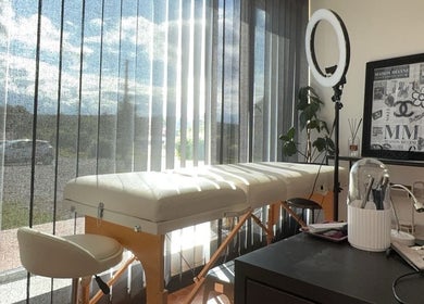 Cabine lumineuse de Maison Mélyne, Bertrichamps, Grand Est, FR, avec table de massage et décoration élégante.