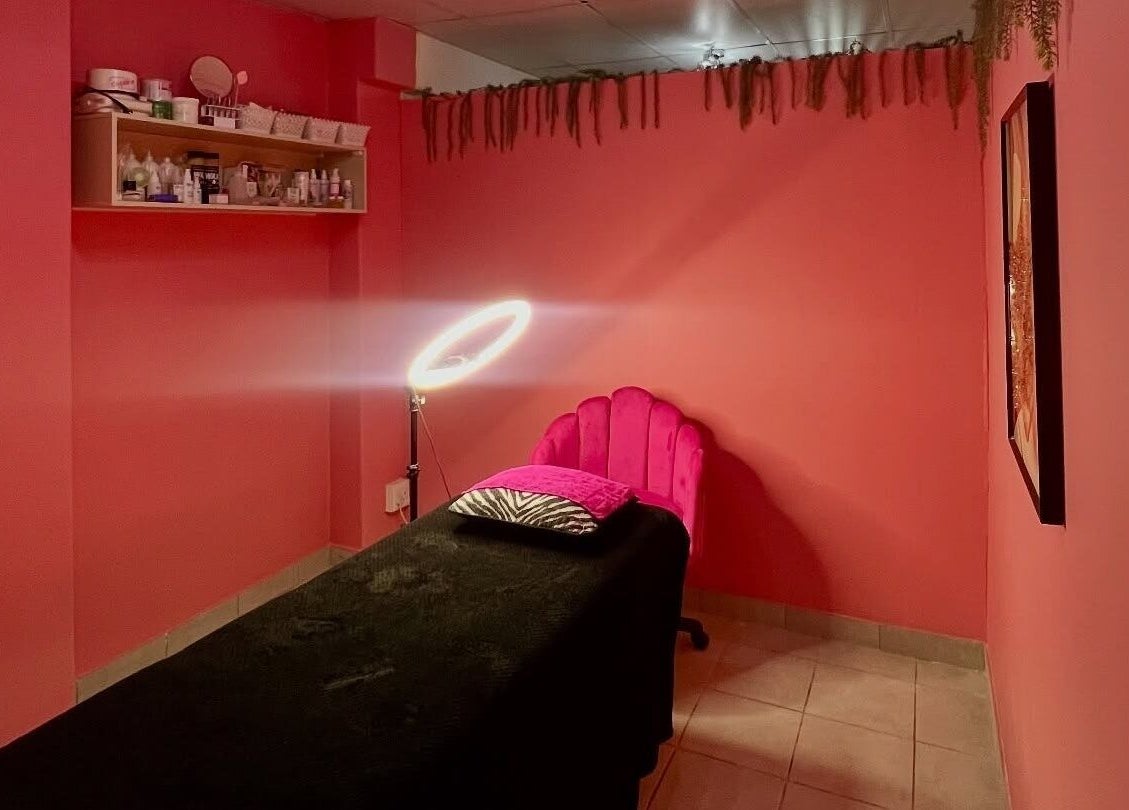 A cozy treatment room at Peaches Beauty Bar, Edenvale, Gauteng, ZA, with pink walls and ambient lighting.