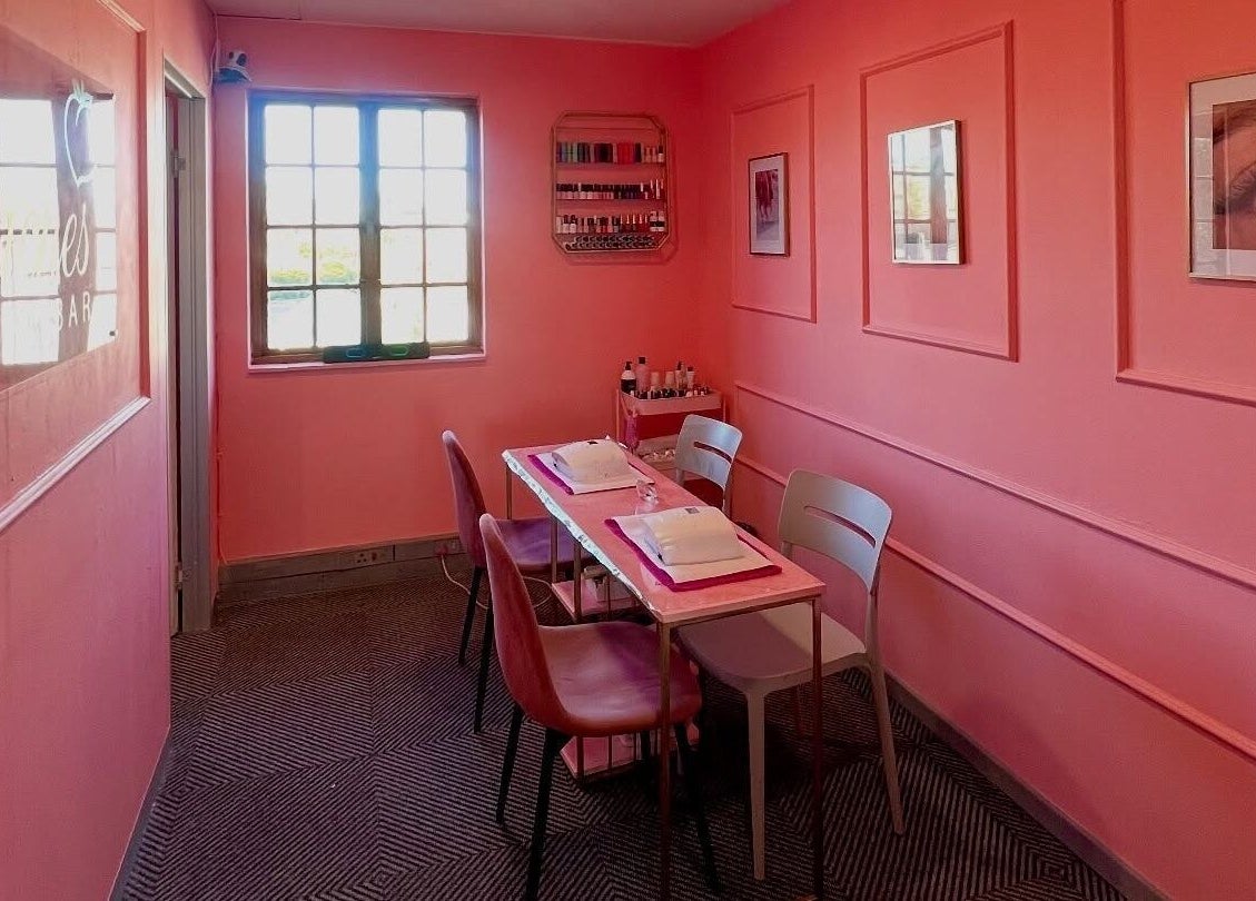 Chic nail salon setup at Peaches Beauty Bar, Edenvale, Gauteng, ZA featuring pink walls and elegant decor.
