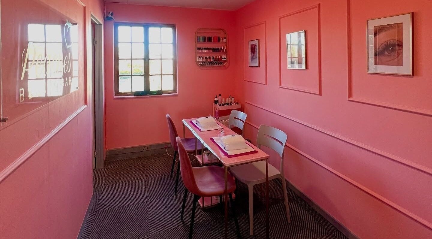 Chic nail salon setup at Peaches Beauty Bar, Edenvale, Gauteng, ZA featuring pink walls and elegant decor.