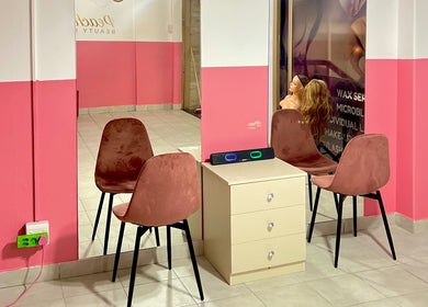 Cozy seating area at Peaches Beauty Bar, Edenvale, Gauteng, ZA with pink decor and modern chairs.